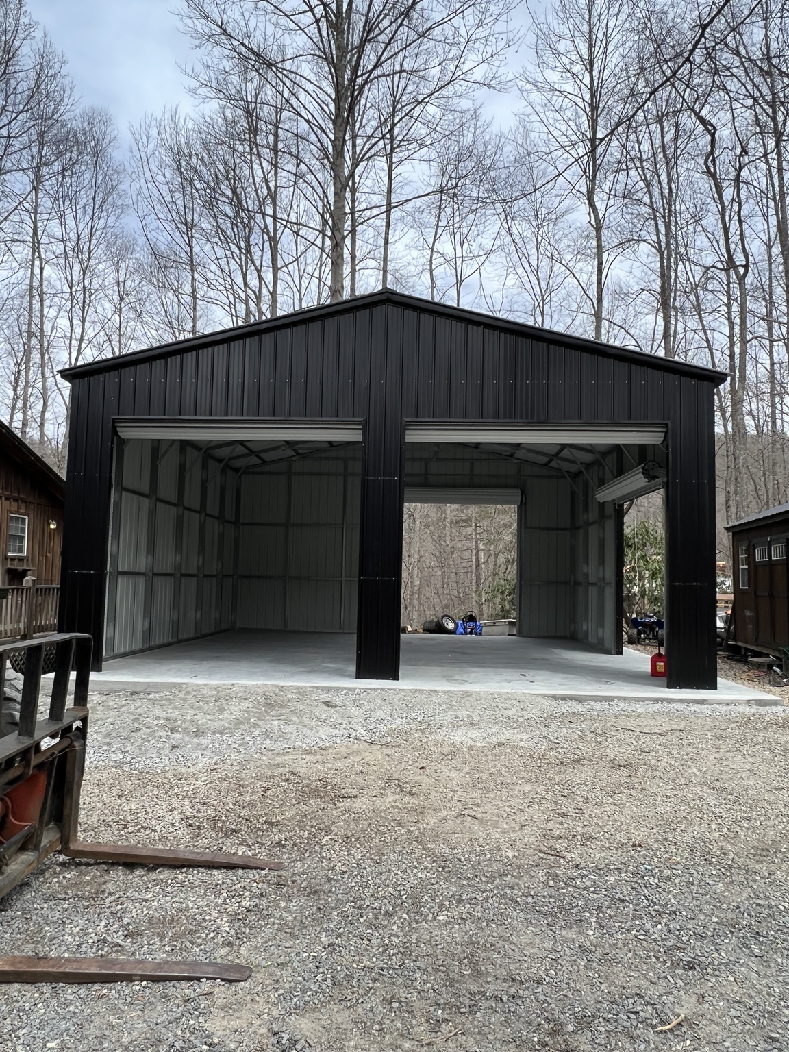 Black garage with two open roll-up doors