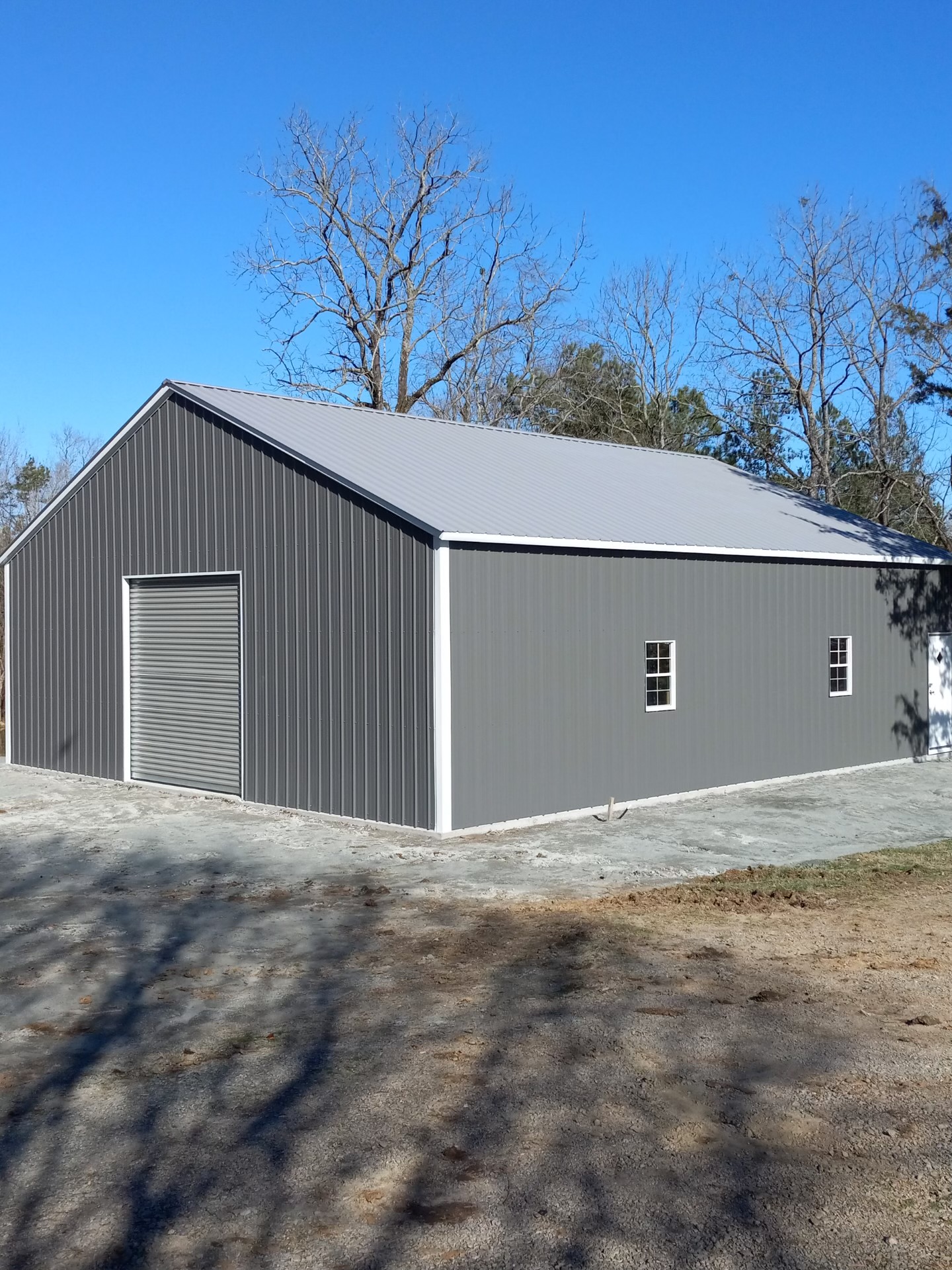 Gray storage building with windows and a roll-up door